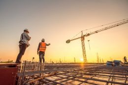 silhouette group of worker and civil engineer  in safety uniform install reinforced steel column in construction site during sunset time industrial concept